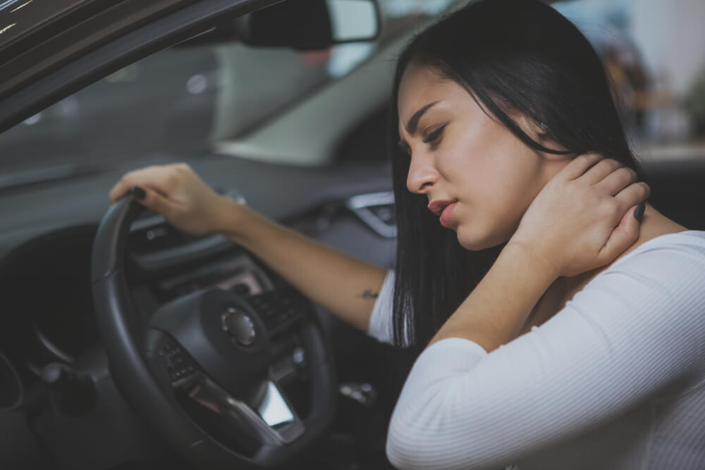 Woman experiencing neck pain after a car accident, showing delayed injury symptoms common in Texas collisions