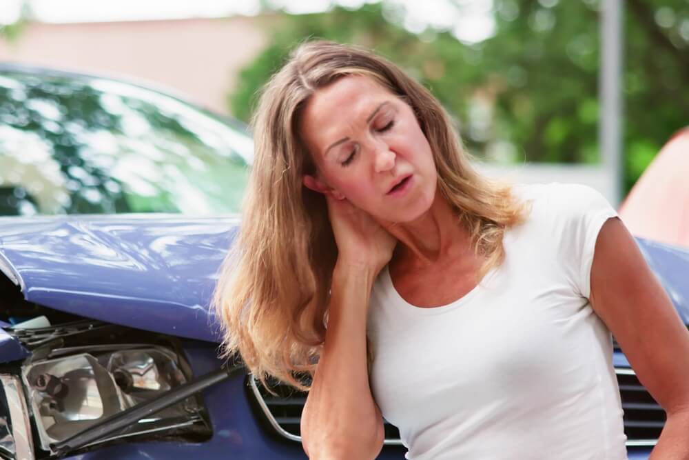 Woman holding her neck in pain after a Texas car accident, showing possible whiplash symptoms.