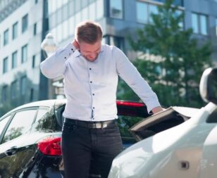 Injured driver holding his neck after a Texas car accident, illustrating pain and suffering damages.