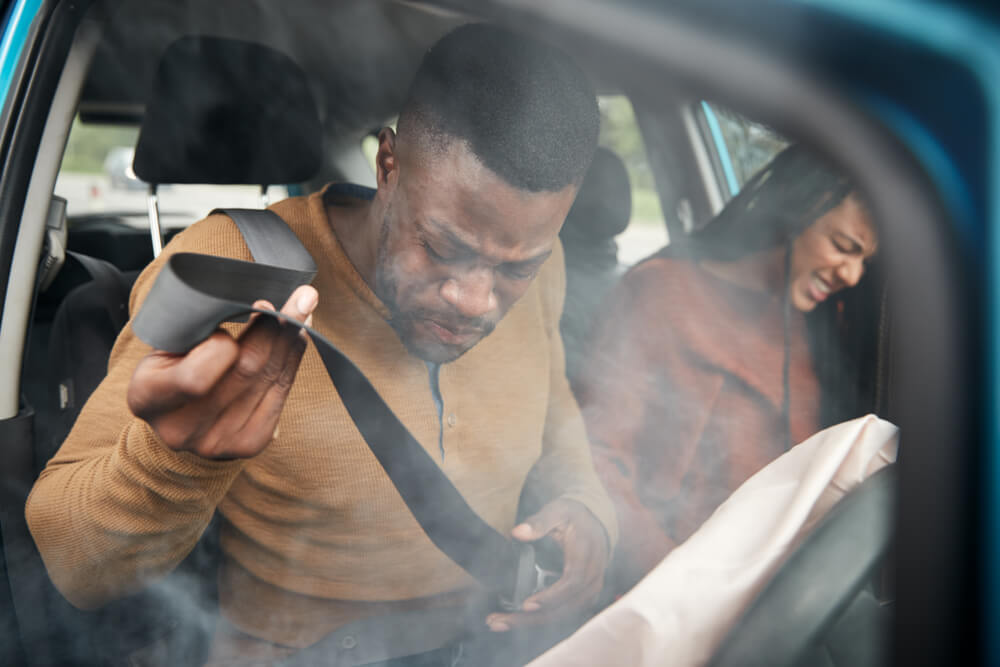 Injured passengers in a Texas car accident holding seatbelts after crash.