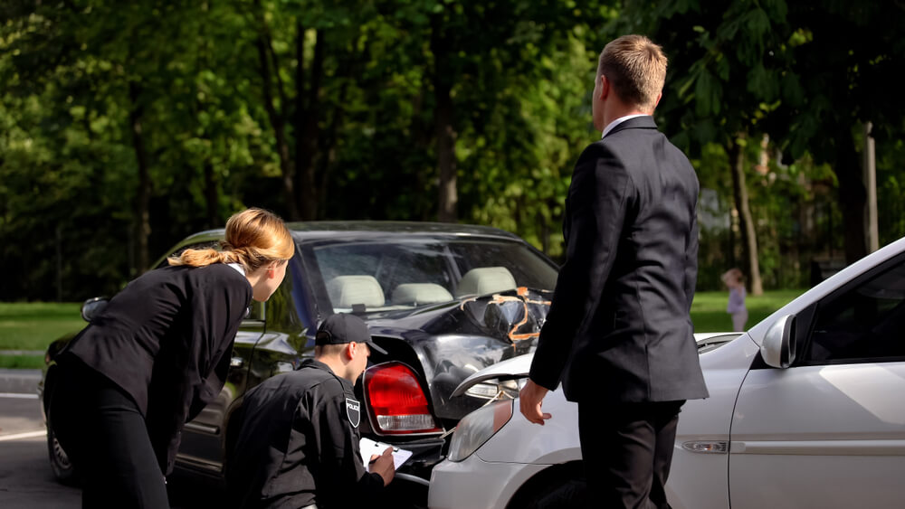 Police officer writing a Texas car accident police report at crash scene